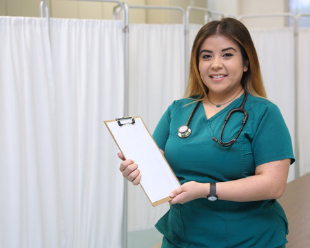 Portrait of an attractive female hispanic healthcare professional with copy space clipboard.
