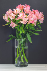 Pink alstroemerias in a vase on a black background