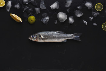Fresh sea bass with ice at black background