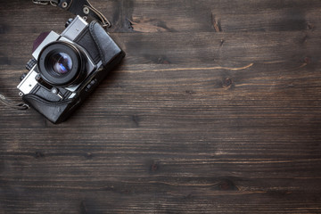 Old retro camera on wooden table background