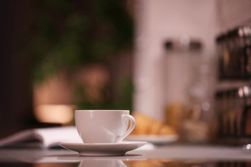 Cup of hot coffee on blurred background