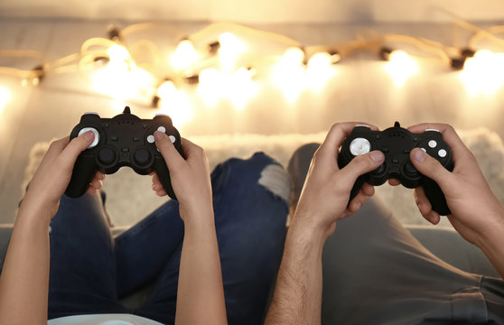 Young couple playing video game at home, closeup