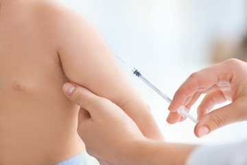 Obraz na płótnie Canvas Doctor vaccinating baby in clinic, closeup