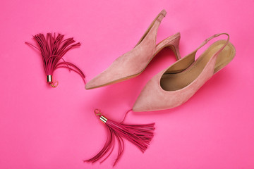 Classic female shoes and earrings on color background