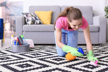 Woman cleaning carpet in living room