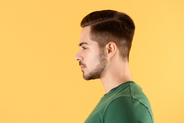 Fototapeta premium Portrait of young man with beautiful hair on color background