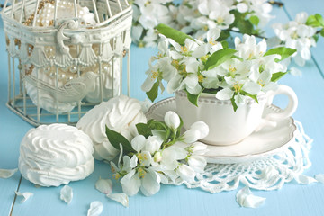 Romantic composition with tea cup, zephyr and apple flowers  