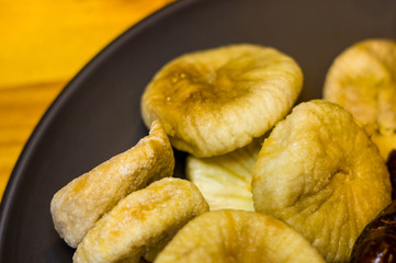 dried figs in a ceramic plate on a wooden table
