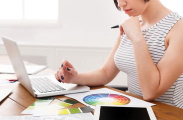 Young designer working with blueprints in the office