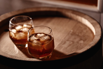Glass of whiskey on wooden background close up