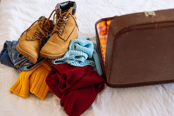 woman clothes near old vintage suitcase. travel concept. prepari