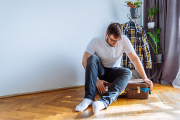 man need help to close suitcase. overloaded bag with clothes. travel concept
