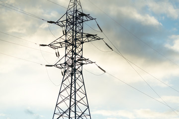 High voltage electricity pylons and transmission power lines on the blue sky background