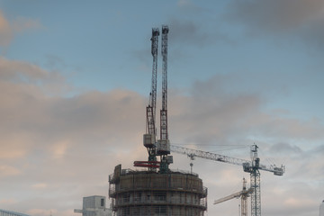 Construction of a residential complex. four cranes near construction building.