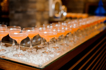 Set of glassed arranged in line on bar and filled with fresh and sweet cocktails