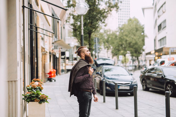 Young man with the beard goes to the office. on the back you have a classic style jacet