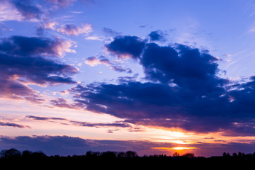 Obraz premium Vivid color clouds on sunset landscape. Blue sky with bright pink, yellow and purple