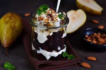 Creamy dessert with chocolate biscuit, caramel pear and almonds.