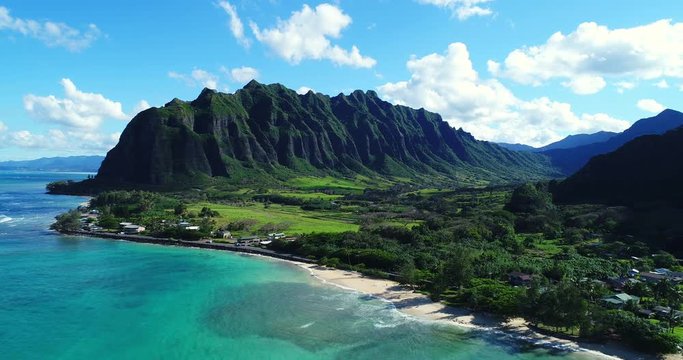 Aerial view flying towards lush jungle mountain landscape on the east side of Oahu in Hawaii 