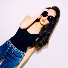 Brunette Girl in black swimsuit and trendy sunglasses. Beach fashion vibes