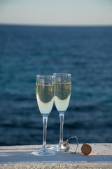 Two glasses with champagne or cava served outside on terrace, luxury resort with sea view, romantic vacation