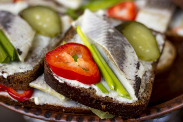Sandwich with herring, marinated cucumber, onion and pepper