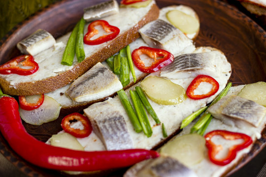 Sandwich with herring, marinated cucumber, onion and pepper