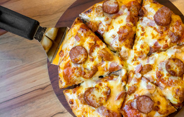 pizza with bacon ham and sausage on wooden table