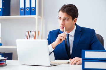 Young handsome businessman employee working in office at desk