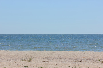 A deserted beach on the edge of the Earth, a clear sea on a summer day, an empty beach and a clear sky, a minimalistic landscape near the ocean, a copy of the space, rest on a deserted island
