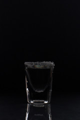 tequila with salt on black background