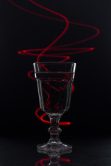 glass of water ob black background with red light
