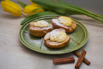 baked apple  with cottage cheese, cinamon sticks and yellow tulips.