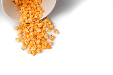 roasted yummy popcorn scattered from a bucket on a white background