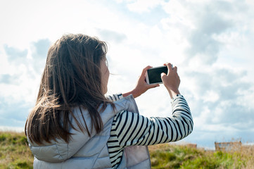 Cheerful girl taking picture in Scottish Highlands