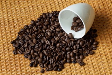Roasted coffee beans in white mug on table