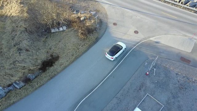 White Audi A1 driving on beautiful coastal road bridge with sunset. 