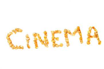 grains of yellow roasted popcorn lined in the word 'cinema'