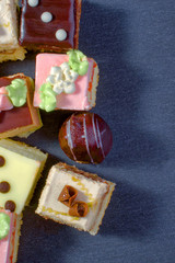 Assorted colorful natural sweet cakes on a black background. Copy space for text.  Concept of tasty cakes. Food background. Top view.