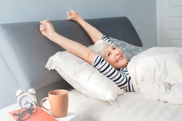 Happiness elderly woman woke up in the morning and smiling