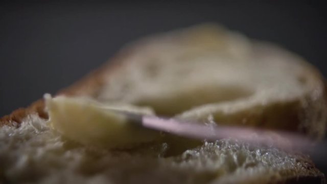 The butter is slowly smeared onto the bread.