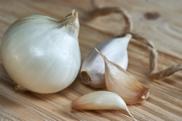 Garlic, onion, bay leaf, black pepper on a wooden table. Food background. Garlics. sliced garlic, garlic clove, garlic bulb.