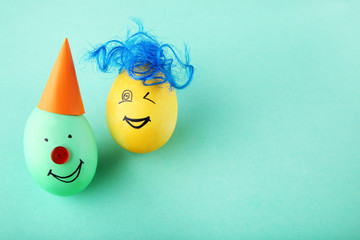 Eggs with funny faces on mint background