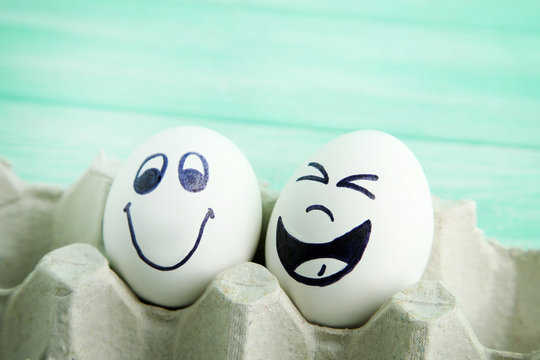Eggs with funny faces in carton package