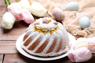 Easter cake with eggs and tulip flowers on wooden table