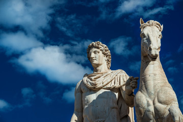 Ancient marble statue of Castor or Pollux with horse, dated back to the 1st century BC, located at the top of monumental balustrade in Capitoline Hill, in Rome (among clouds)