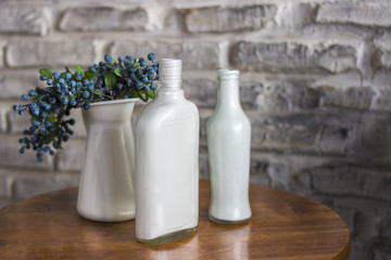 a branch of blueberries with berries in a blue vase close up. Blueberry in a white vase. White vases and blueberries. A bush of blueberry, bog whortleberry, great bilberry.