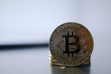 Golden Bitcoin facing the camera in sharp focus, closeup