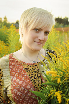 Girl among wildflowers looks at the camera.