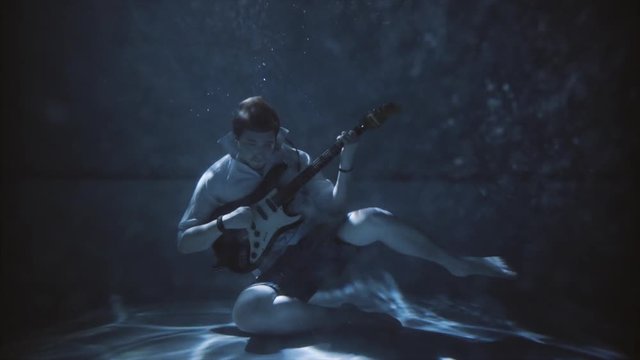 men underwater in pool, men dive underwater and playing on guitar